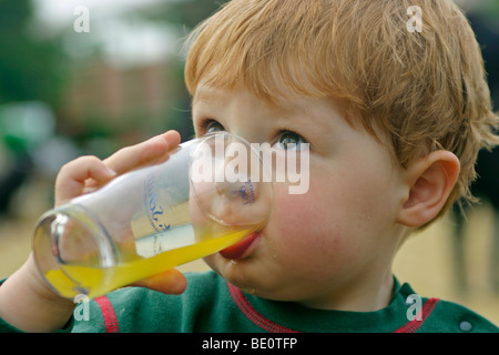 Portrait d'un petit garçon de boire dans un verre Banque D'Images