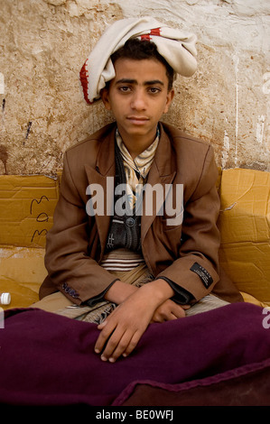 Un portrait d'une jeune marchand de khat yéménite, assis dans le vieux souk de khat de Sanaa, Yémen. Banque D'Images