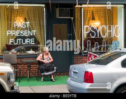 Une femme assise à l'extérieur d'un magasin psychique à Greenwich Village, New York City USA Banque D'Images