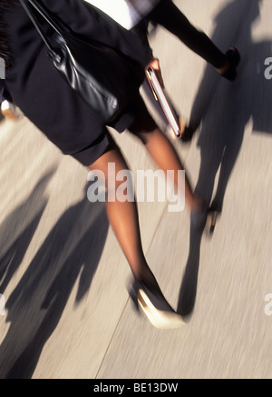 New York City femme d'affaires à talons hauts et une jupe se précipitant pour travailler Shadows USA Banque D'Images