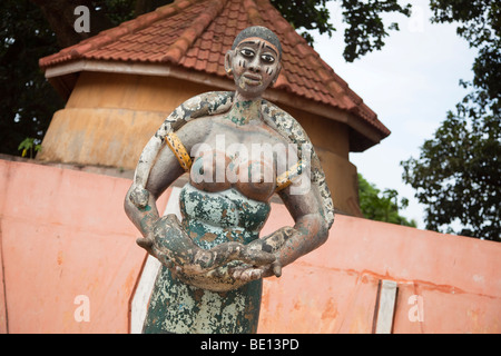 En dehors du Temple de pythons dans Oudiah, Bénin, un une statue de femme avec un python. Banque D'Images