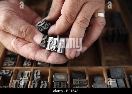 Printer's hands holding laisse entrer des nombres Banque D'Images