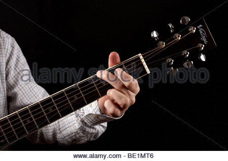 Homme jouant G Chord sur guitare acoustique Banque D'Images