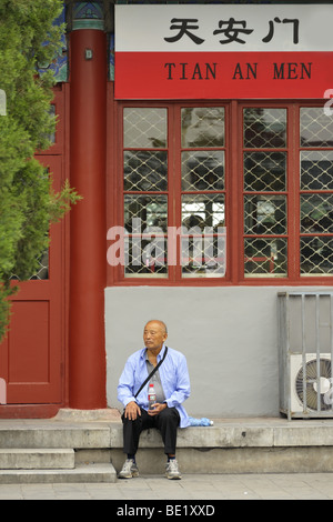 Un vieil homme assis en face d'une boutique touristique, Beijing CN Banque D'Images
