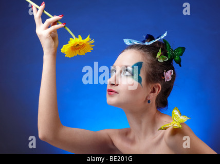 Portrait de beau modèle avec papillon et artificail bodyart papillons sur son doigt et sèche, holding flower dans sa main Banque D'Images