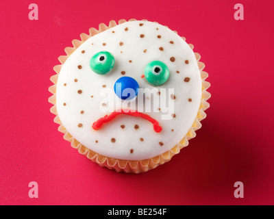 Triste VISAGE BOUTONNEUSES CUPCAKE Banque D'Images