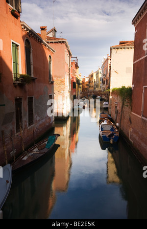 Photographie verticale d'un Canal Vénitien avec les bâtiments reflètent Banque D'Images