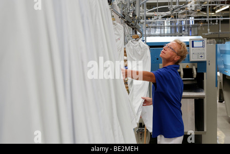 Rosalie Herr travailler avec une machine de pliage et de répandre dans la partie blanche d'une blanchisserie industrielle, Bardusch Renta uniforme Banque D'Images