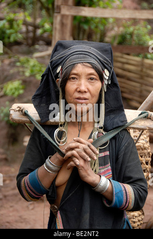 Portrait, l'ethnologie, femme de l'ethnie Akha Pixor en vêtements traditionnels, hood comme un couvre-chef, transportant un panier avec yok Banque D'Images