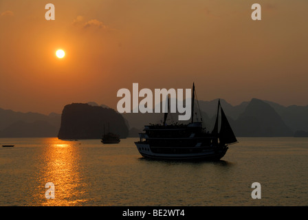 Silhouette d'un Junk au coucher du soleil en face de montagnes coniques, Ha Long Bay, Vietnam, Asie du Sud, Asie Banque D'Images