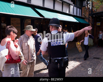 Agent de police donne des directives à un touriste dans le Lion et l'agneau à la cour. Farnham, Surrey. UK Banque D'Images