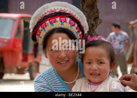 Portrait, l'ethnologie, femme de l'ethnie Bai avec couvre-chef typique et un bébé, Yongning, région du lac Lugu Hu, Yunnan P Banque D'Images