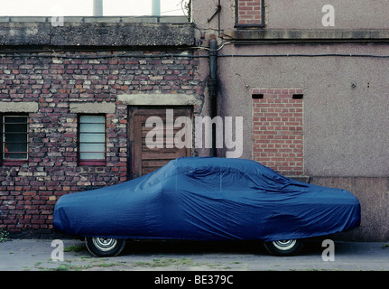 Voiture garée dans un jardin vert avec des couverts avec une bâche, couverture de voiture, Duisburg, Germany, Europe Banque D'Images