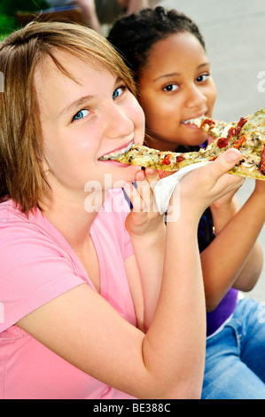 Deux adolescentes assis et eating pizza Banque D'Images