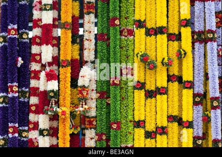 Des guirlandes de fleurs imitation utilisé dans le culte religieux hindous sur une échoppe de marché en Inde Banque D'Images