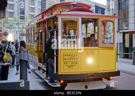 San Francisco Cable car numéro 15 jaune Red Powell Market route San Francisco Californie // SAN FRANCISCO, Californie — San FRANCISCO Cable car numéro 15, un véhicule classique jaune et rouge, circule le long de son itinéraire. Le panneau sur la voiture indique qu'elle relie Powell et Market à des destinations comme Bay & Taylor et Fisherman's Wharf, qui font partie des lignes emblématiques du système. Les passagers sont vus à bord de ce transport public par excellence, qui est une attraction populaire et une façon unique de découvrir la ville. Le système de téléphérique de San Francisco, créé en 1873, est un monument historique national. Banque D'Images
