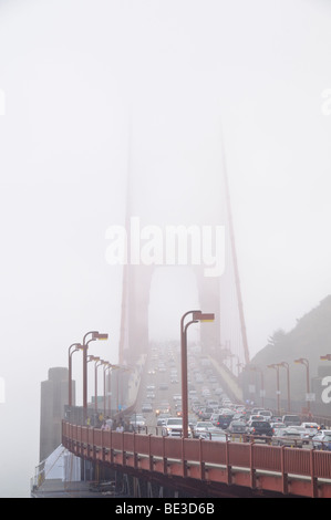 Pont du Golden Gate piétons à trafic lourd brouillard San Francisco États-Unis // SAN FRANCISCO, Californie — le pont du Golden Gate est entouré d'un brouillard dense, avec des véhicules en trafic intense traversant sa travée et des piétons sur sa passerelle. Ce pont suspendu emblématique relie la ville de San Francisco au comté de Marin, enjambant le détroit du Golden Gate. Achevé en 1937, il s'agissait d'une réalisation d'ingénierie monumentale et de la plus longue travée de pont suspendu au monde à l'époque, mesurant 2,7 kilomètres (1,7 milles). Le pont est une artère de transport vitale et un symbole mondialement reconnu de San FR Banque D'Images