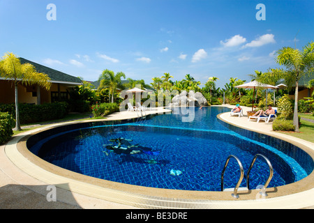 La formation des plongeurs, les touristes sur les chaises longues près de la piscine, bungalows avec green surroundings, Palm Garden Resort, Khao Lak, Phuket, Thail Banque D'Images
