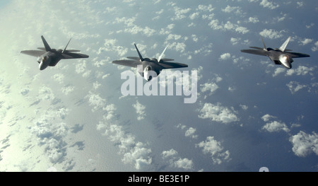 Une formation de trois appareils F-22 Raptors voler au-dessus de l'océan Pacifique au cours d'une mission de guerre du Pacifique. Banque D'Images