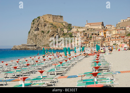 Chaises longues sur une plage, vieille ville avec château à l'arrière, sur les falaises côtières, en mer Tyrrhénienne, Scilla, Calabre, Italie du Sud Banque D'Images