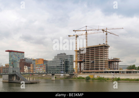 Grand site en construction media port Medienhafen de Düsseldorf, l'enveloppe du bâtiment de l'hôtel à côté d'immeubles de bureaux avec 'Flossis', l'K Banque D'Images