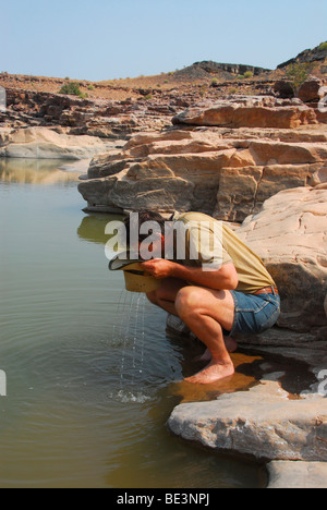 Boire de l'randonneur Fish River dans la région de Fish River Canyon, Namibie, Afrique Banque D'Images