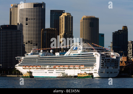 Sydney ferries sont éclipsées par un bateau de croisière amarré au terminal passagers d'outre-mer à Circular Quay. Sydney, Nouvelle Galles du Sud Banque D'Images