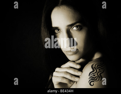 Le noir et blanc portrait de la jeune femme attrayante blanc avec un tatouage sur son épaule Banque D'Images