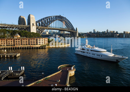 Un yacht de luxe motors dans Campbell's Cove avec le Sydney Harbour Bridge au-delà. Sydney, New South Wales, Australia Banque D'Images