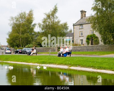 Les gens se détendre au bord de la Canardière à Hartington Village, dans le Derbyshire Peak District England UK Banque D'Images