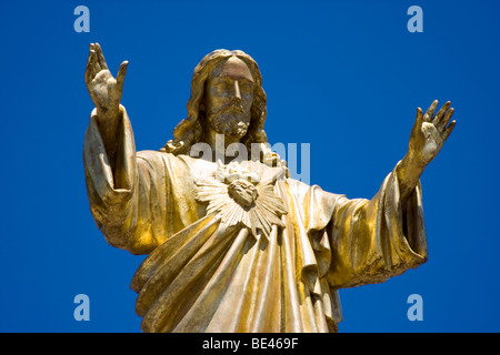 Statue d'or de Jésus le Christ entouré de ciel bleu à la 'Ssanctuaire de Notre-Dame de Fatima' à Fatima, Portugal. Banque D'Images