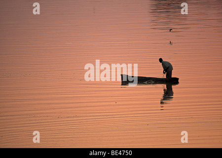 Pêcheur dans la lumière rouge du coucher de soleil sur la Rivière Luangwa, en Zambie, l'Afrique Banque D'Images