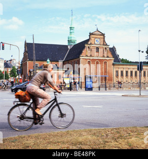 Une jeune femme à vélo près de Borsgade bâtiment à Copenhague Danemark KATHY DEWITT Banque D'Images