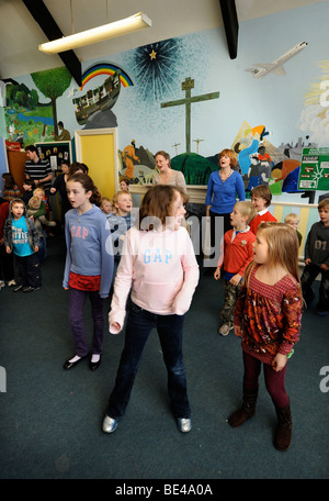 Les enfants chantent et dansent DANS UN GROUPE À UNE ÉCOLE DU DIMANCHE UK Banque D'Images