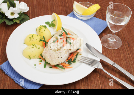 Filet de lieu noir à la vapeur sur un lit de légumes colorés avec des pommes de terre Banque D'Images