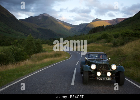 Route de montagne sinueuse avec voiture classique, Glen Nevis, Ecosse Banque D'Images