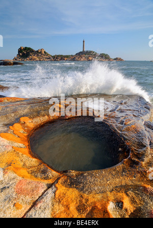 Surf et de grès du bassin d'eau dans la baie de Ke Ga, dans l'arrière plus haut, 54m, et le plus ancien, 1897, phare, Vietnam, Asie Banque D'Images