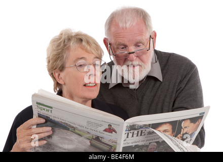 Couple de retraités plus âgés journal lecture ensemble Banque D'Images