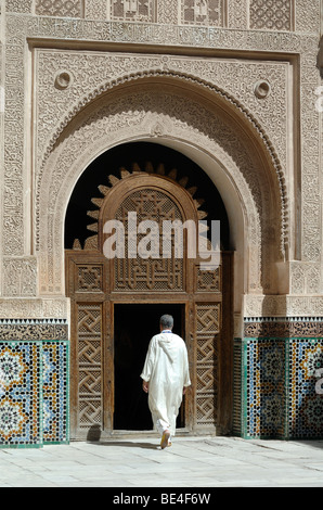 Entrée principale et homme marocain à la Madrasa Ali Ben Youssef (1564-65), à la Madrasa, à la Medresse ou à l'École coranique islamique, Marrakech, Maroc Banque D'Images