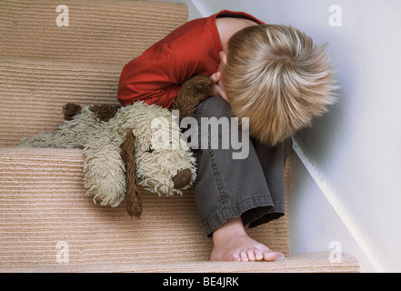 Concept de l'enfant perturbé avec son jouet chien. Banque D'Images