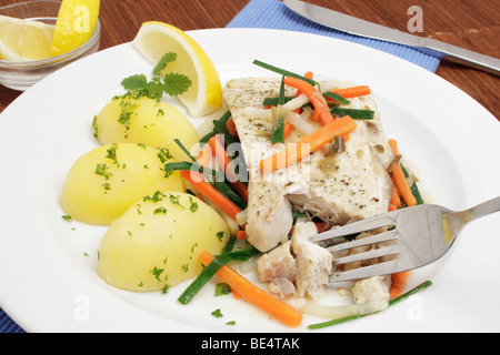 Filet de lieu noir à la vapeur sur un lit de légumes colorés avec des pommes de terre Banque D'Images