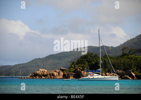 Catamaran en face de rochers de granit, l'île Curieuse, Seychelles, Afrique, Océan Indien Banque D'Images