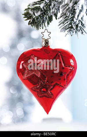 En forme de coeur rouge décoration de Noël sur le sapin enneigé Banque D'Images