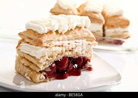 Morceau de pâte feuilletée cake aux cerises et de la crème Banque D'Images