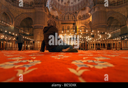 Mosquée Bleue, Sultan Ahmet Camii, salle de prière, un touriste assis sur le tapis, Sultanahmet, Istanbul, Turquie Banque D'Images
