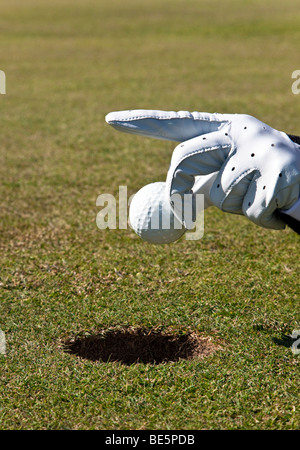 Sans mettre les bâtons de golf, main tenant une balle de golf Banque D'Images