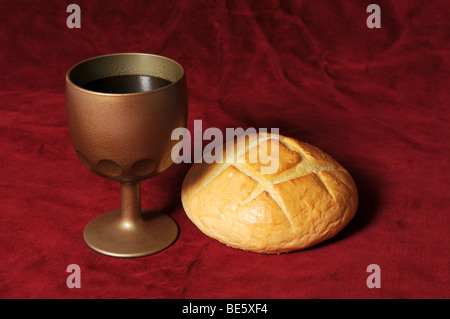 Éléments de communion représenté par le pain et le vin sur un fond rouge Banque D'Images