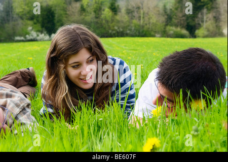 Jeunes, étudiants, allongé sur une prairie au printemps, de parler les uns aux autres, la France, l'Europe Banque D'Images