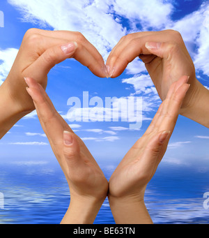 Des mains symbole coeur bleu sur fond marin Banque D'Images