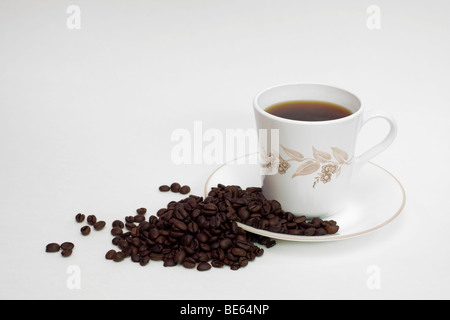 High key tasse de café avec les grains de café. Fond blanc, couleurs neutres. Banque D'Images